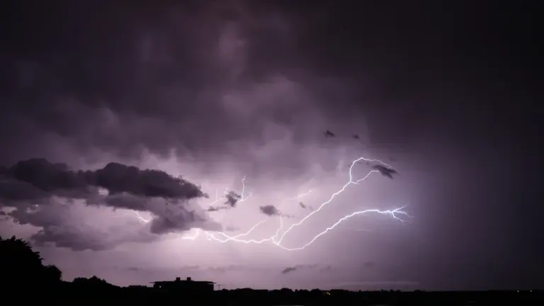 Un orage éclate violemment au-dessus des toits d'une ville française.