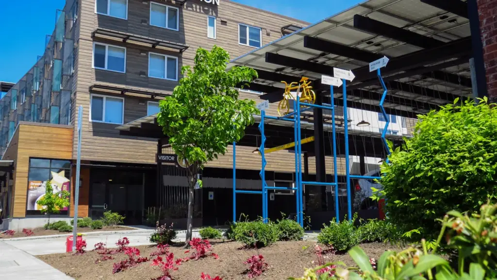 Bâtiment moderne avec une installation artistique représentant un vélo devant une façade urbaine.