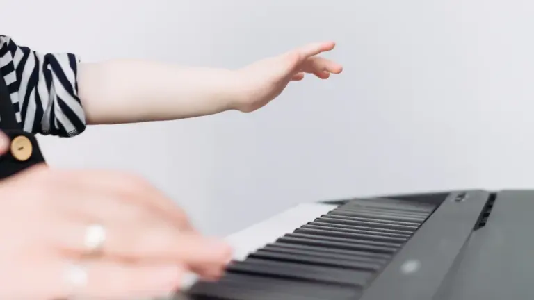 Les mains d'un jeune enfant apprenant à jouer du piano musicalement.
