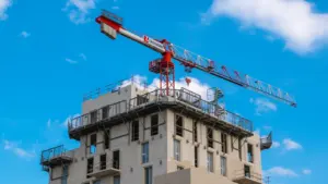 Vue d'une grue sur un chantier de construction à Nantes sous un ciel bleu.