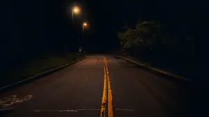 Une route urbaine vide éclairée par des lampadaires pendant la nuit à Perpignan.