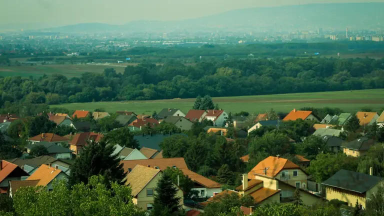 Vue aérienne d'un village français entouré de verdure et d'arbres.