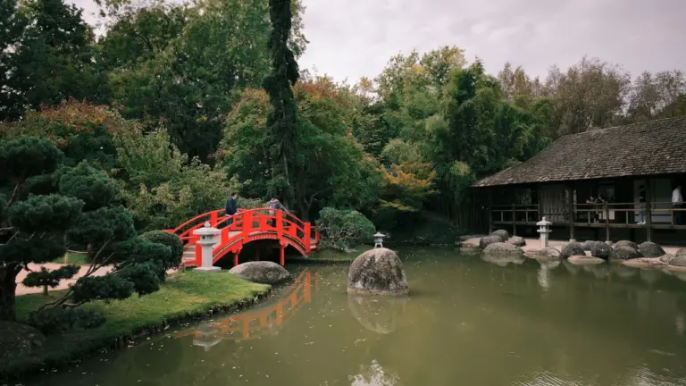 Le Jardin Japonais de Toulouse avec son pont rouge emblématique au-dessus de l'eau.