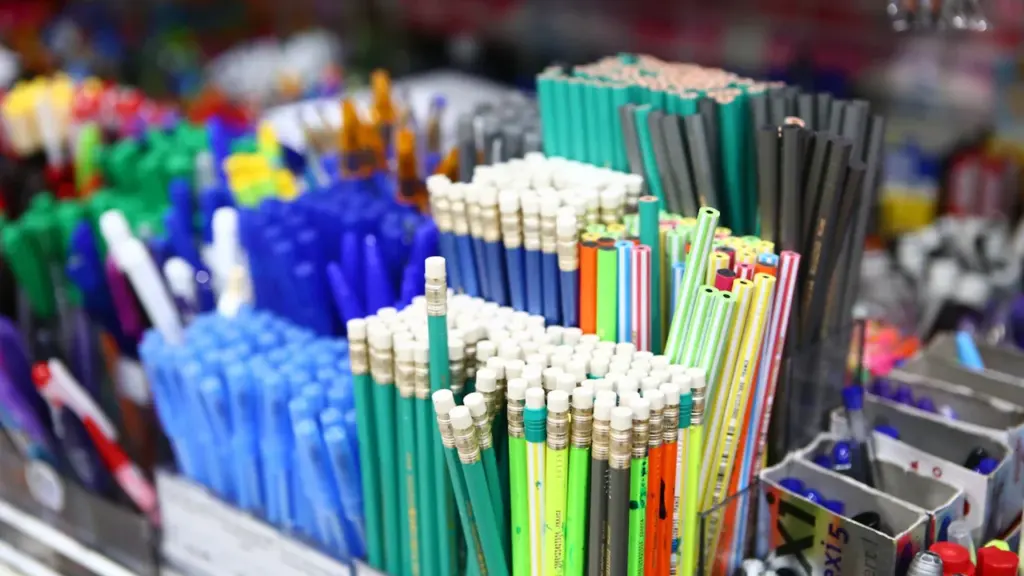 Un assortiment organisé de fournitures scolaires sur fond rouge vif.