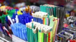 Un assortiment organisé de fournitures scolaires sur fond rouge vif.