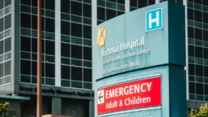 Panneau de signalisation d'urgence devant un hôpital moderne pour informer les patients.