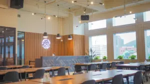 Une salle à manger lumineuse avec des tables et chaises en bois modernes.