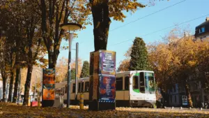 Un tramway circulant dans une rue arborée de Nantes en automne.