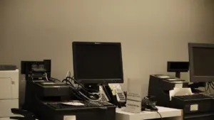 Comptoir administratif avec équipements informatiques et terminaux de paiement dans un bureau public.