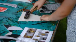 Enfant en train de peindre sur une table lors d'un atelier créatif.
