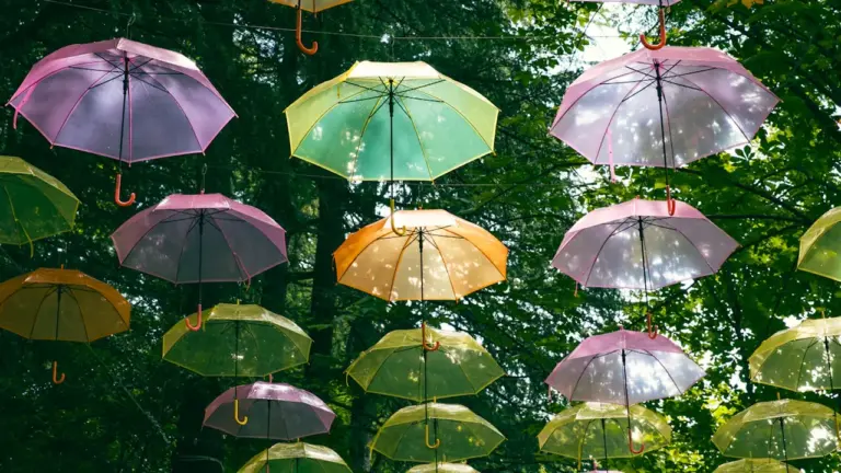 De nombreux parasols colorés suspendus au-dessus d'un espace public en extérieur.