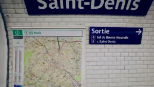 Panneau signalétique de la station de métro Saint-Denis avec plan de ville et sortie.