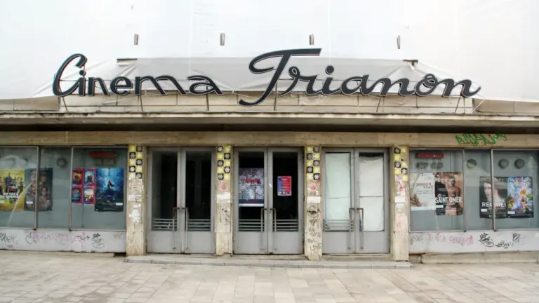 Façade illuminée d'un cinéma traditionnel avec son enseigne rétro en lettres capitales.