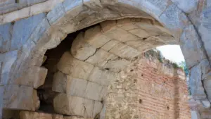 Gros plan sur une ancienne arche en pierre et briques partiellement endommagée à Albi.