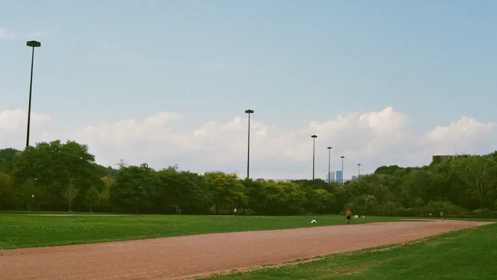 Piste d'athlétisme vide entourée d'espaces verts lors d'une journée ensoleillée.