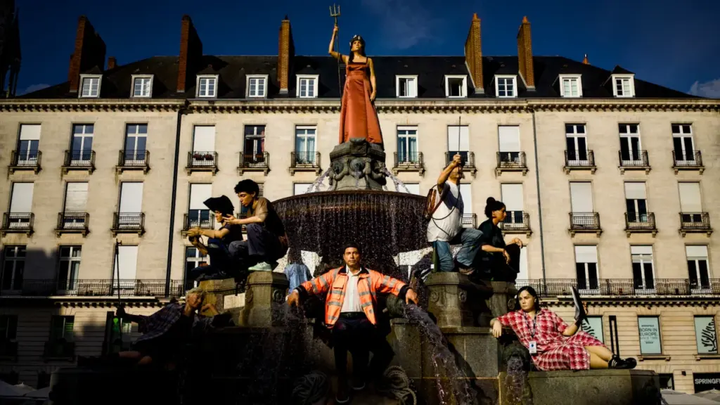 Un groupe de jeunes adultes posant devant une fontaine classique à Lyon.
