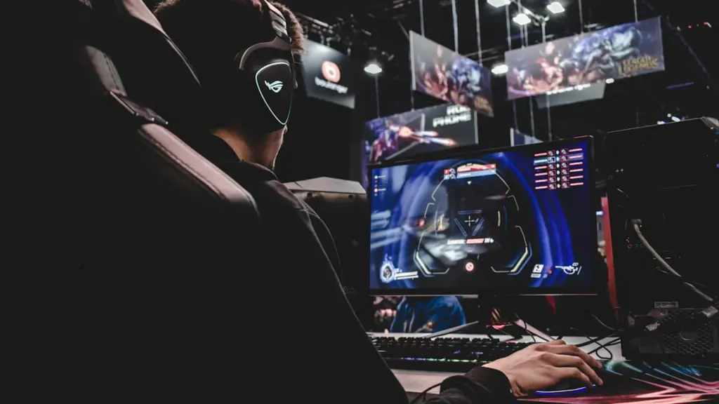 Un jeune joueur concentré devant son écran lors d'une session de jeu intense.