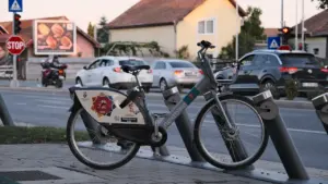 Un vélo en libre-service stationné sur une rue urbaine calme au coucher du soleil.