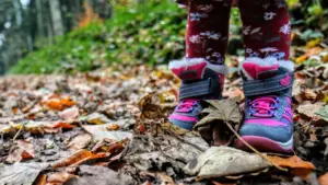 Un enfant marche dans les feuilles mortes automnales au Jardin de l'Arquebuse à Dijon.