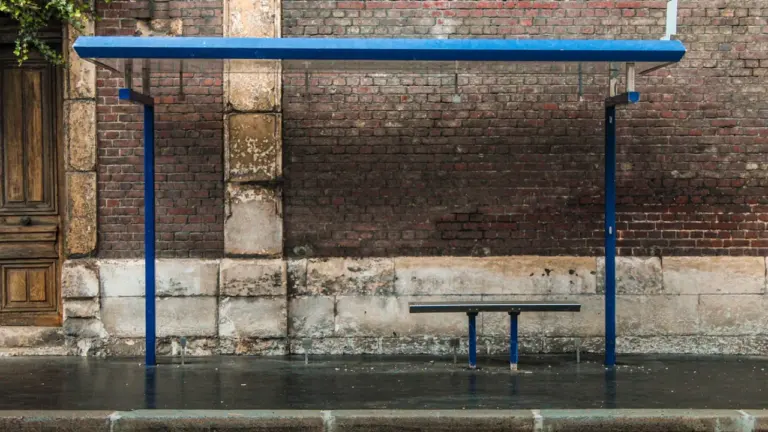Abribus bleu vide devant un mur de briques à Fontenay-aux-Roses