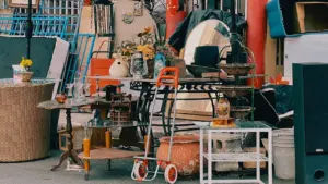 Objets hétéroclites et meubles exposés dans une rue lors d'un vide-greniers.