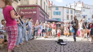Un groupe de musiciens joue de la musique dans une rue pavée animée.