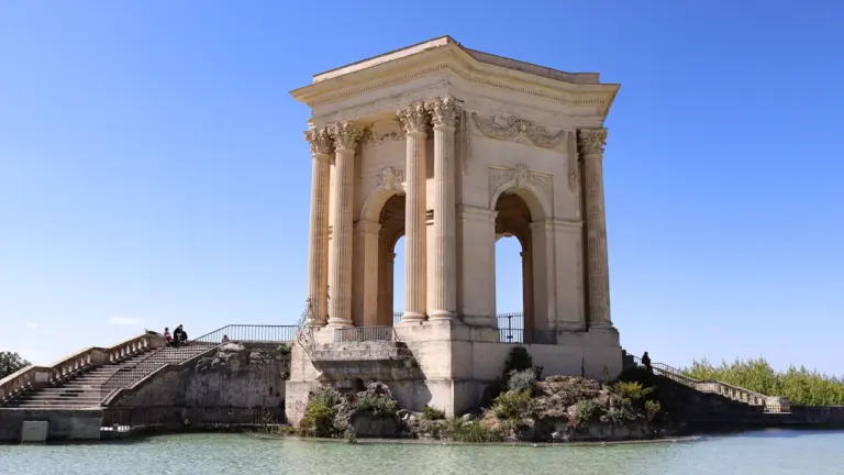 Le Château d'eau du Peyrou à Montpellier sous un ciel bleu estival.