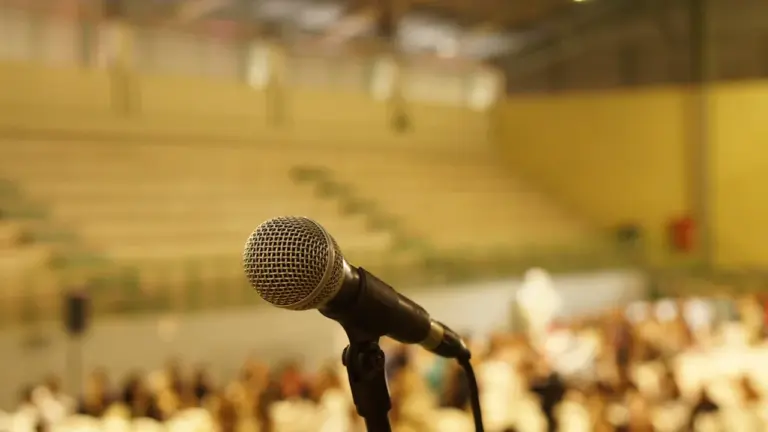 Microphone sur pied devant une salle de conférence floue pour un débat public.