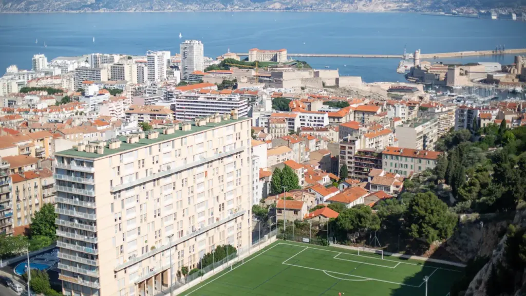 Vue panoramique de la ville de Marseille avec un terrain de football central.