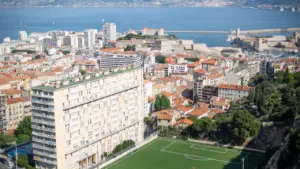 Vue panoramique de la ville de Marseille avec un terrain de football central.