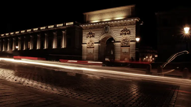 La Porte du Peyrou à Montpellier illuminée la nuit avec des traînées de lumières.